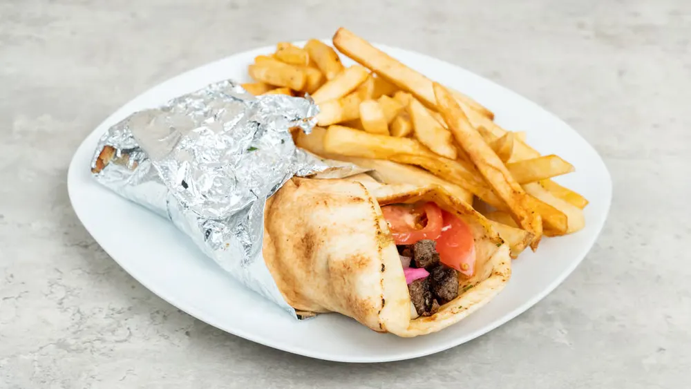 A beef shawarma sandwich with fries