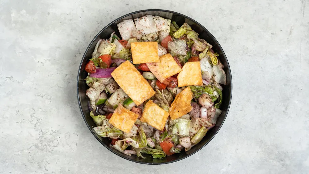 A bowl of fattoush with toasted pita